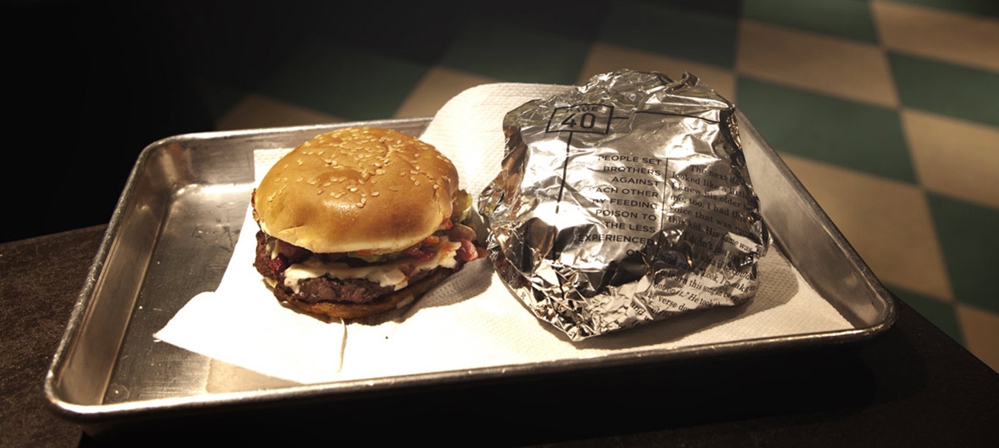 A burger beside another burger wrapped in a page from Jay-Z's memoir