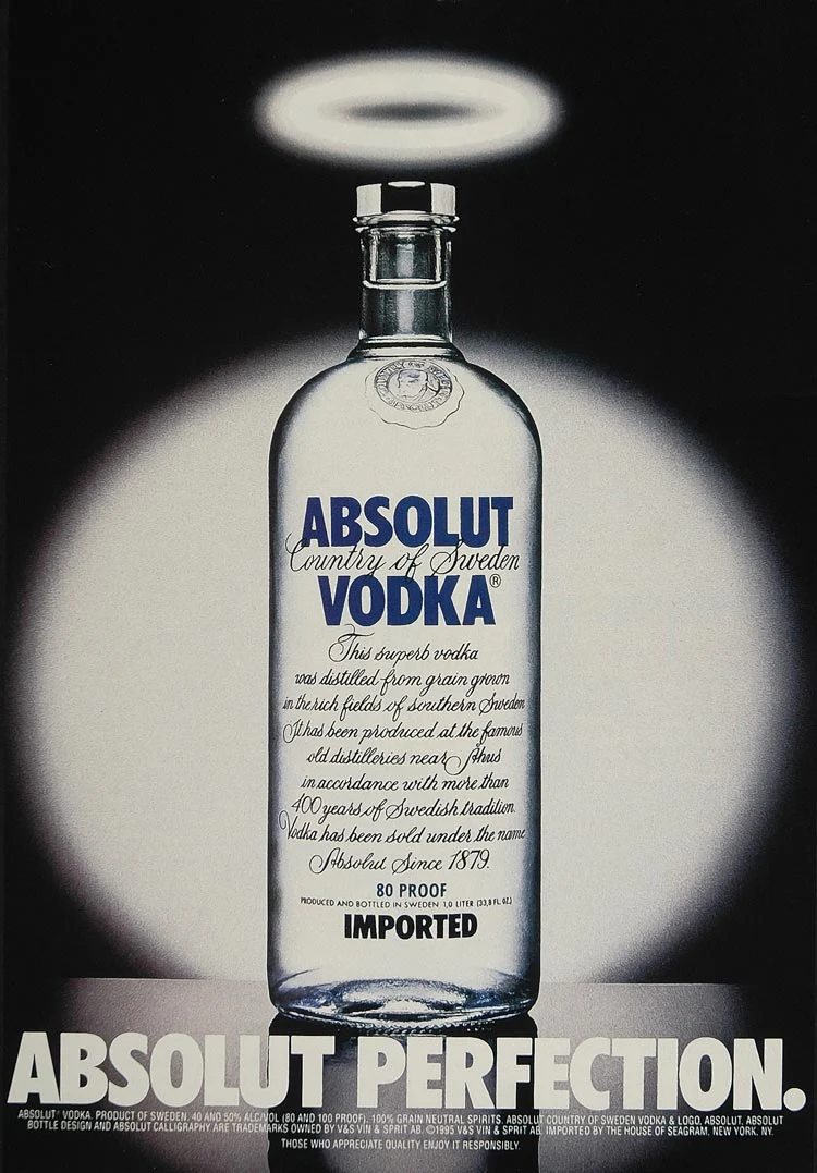 An Absolut vodka bottle beneath a glowing halo against a dark background, with the headline Absolut Perfection.