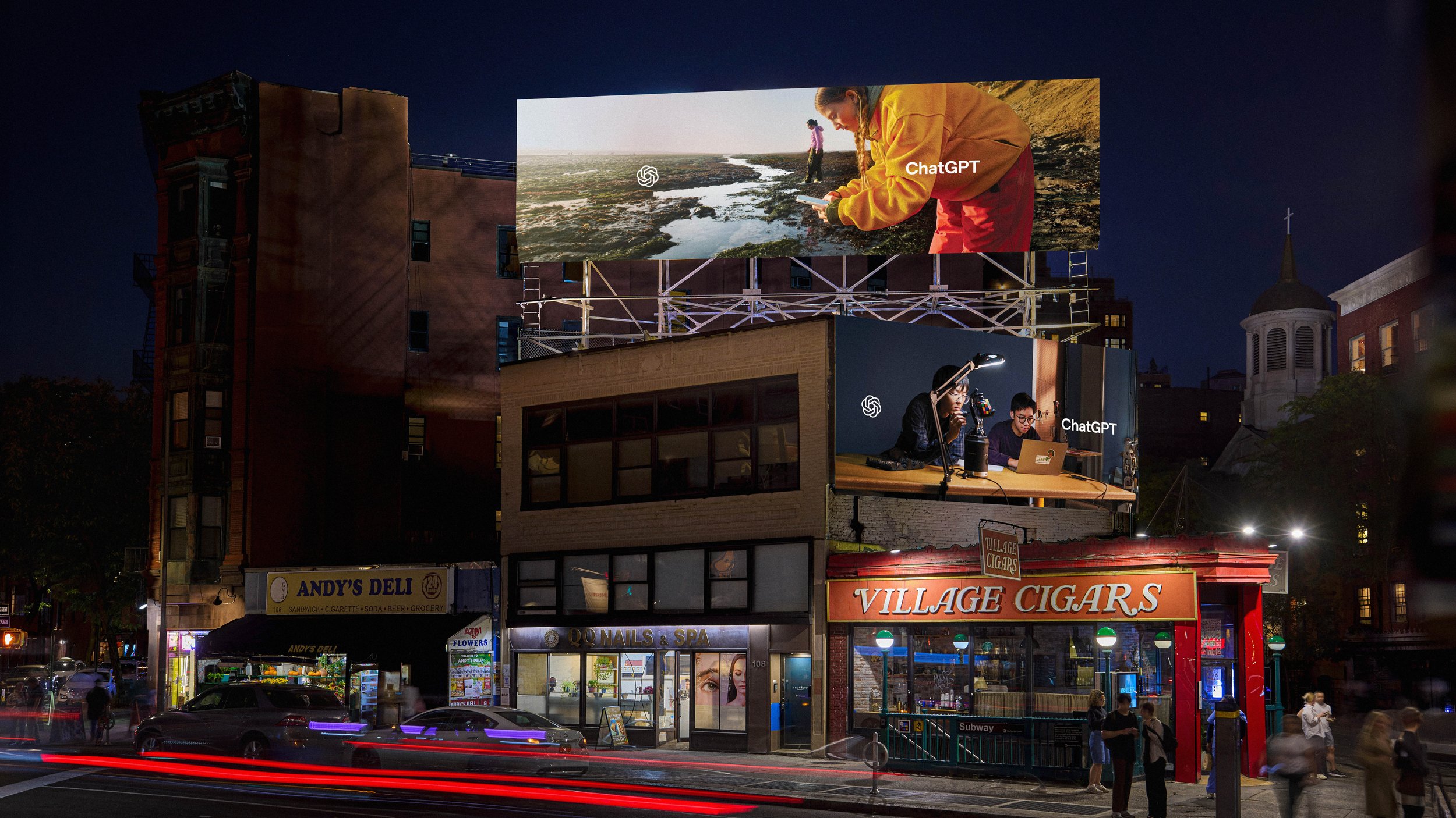 Night view of multiple billboards above a New York street, showing tide-pool and robotics scenes alongside the ChatGPT mark.