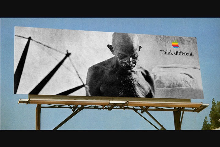 Mahatma Gandhi appears on an Apple Think Different billboard beneath the rainbow Apple logo.