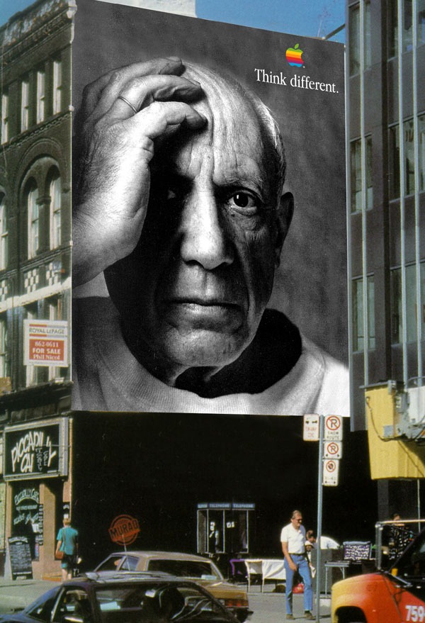 Pablo Picasso appears on a large Apple Think Different wall installation on a city street.